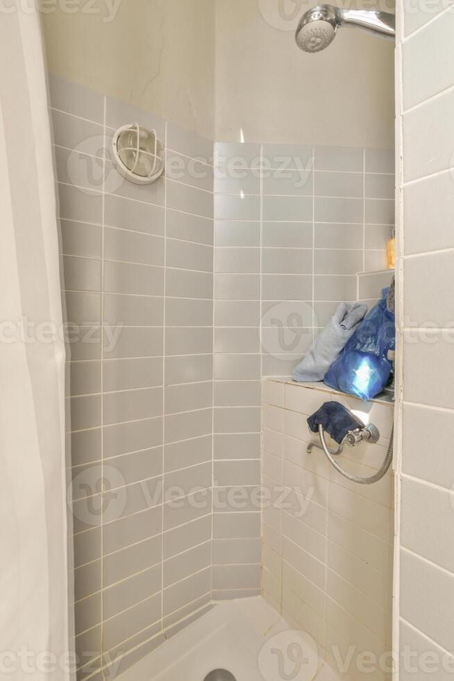 A shower with a blue towel on the wall photo