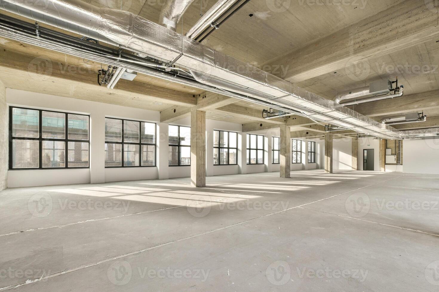 An empty office space with large windows and lots of light photo