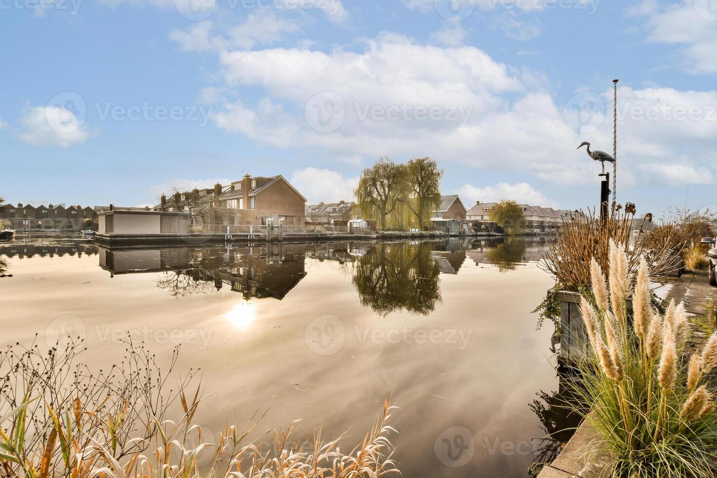 A canal with a boat and a house in the background photo