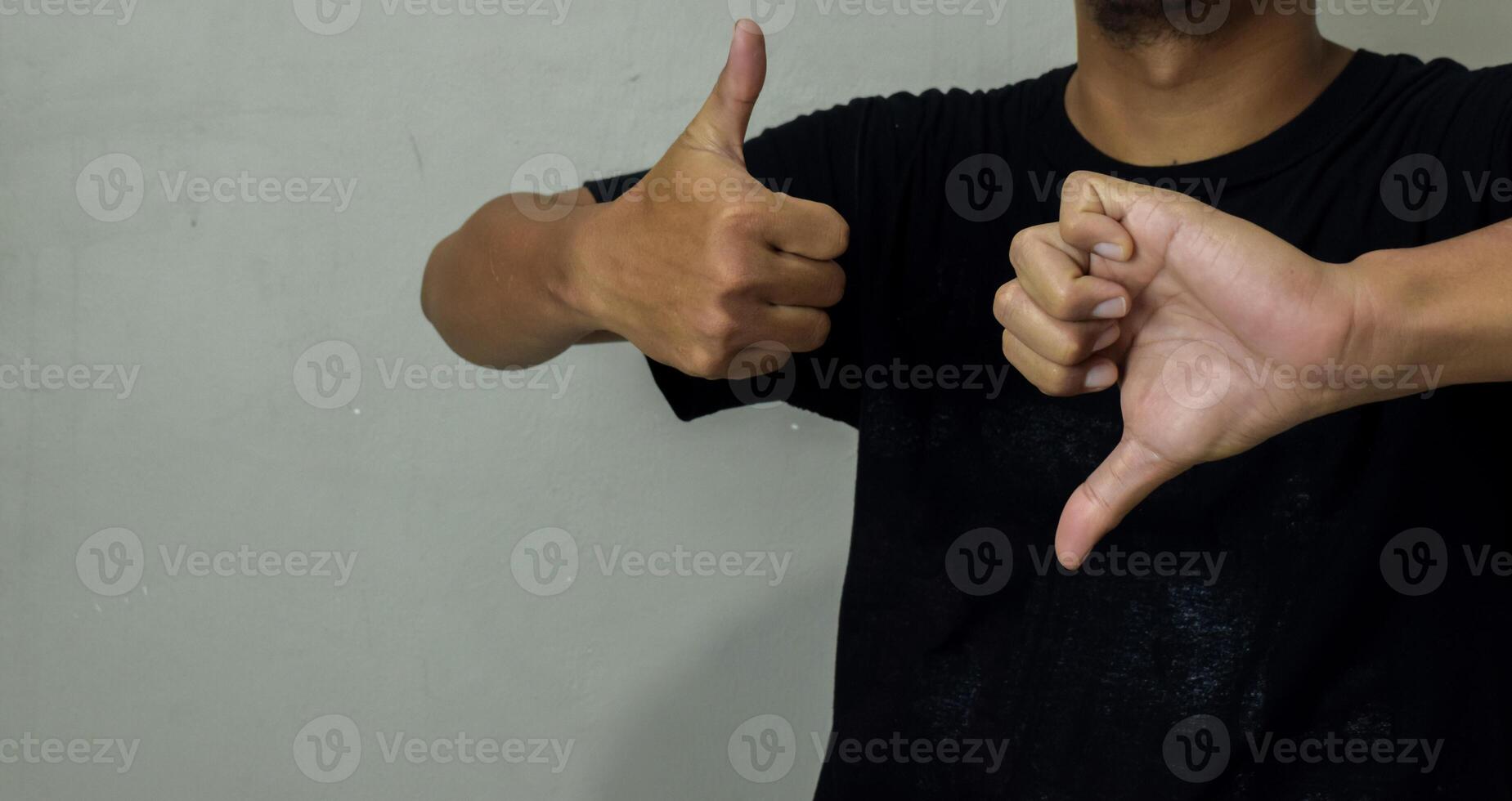 young man showing Thumb up and down gesture in sign language to communicate photo