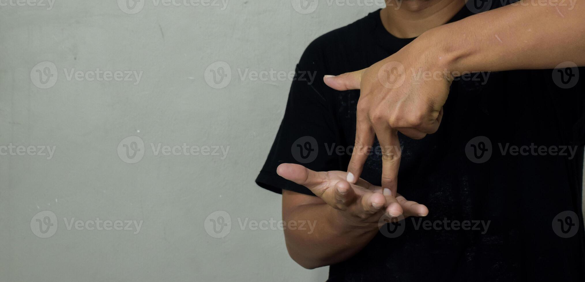 young man showing stand gesture in sign language to communicate photo