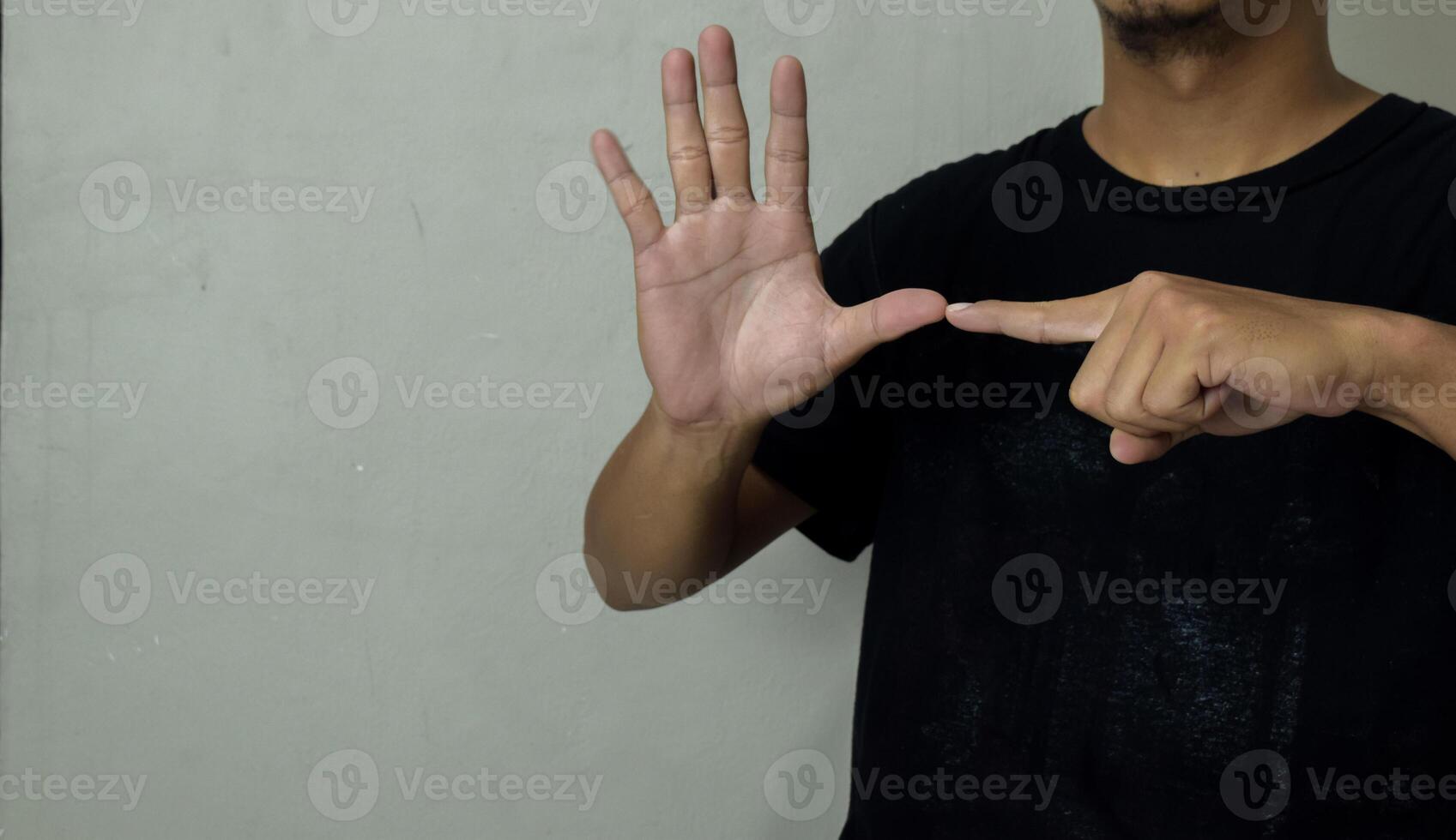 young man showing hearing impaired gesture in sign language to communicate photo