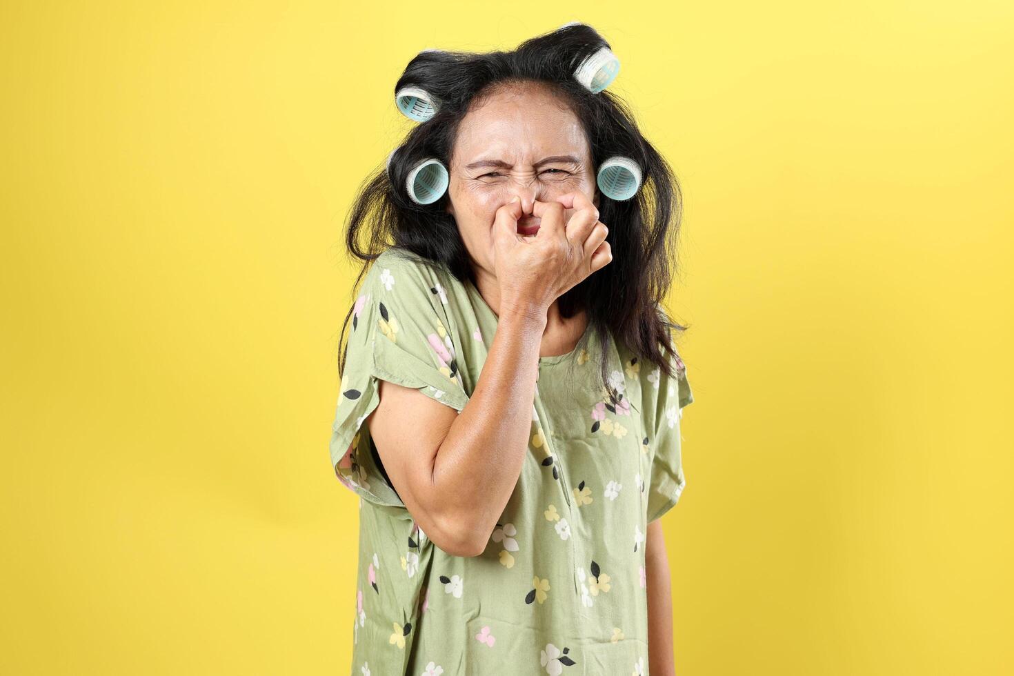 Asian Middle Age Woman Wearing Daster and Rol Rambut Covering Her Nose photo