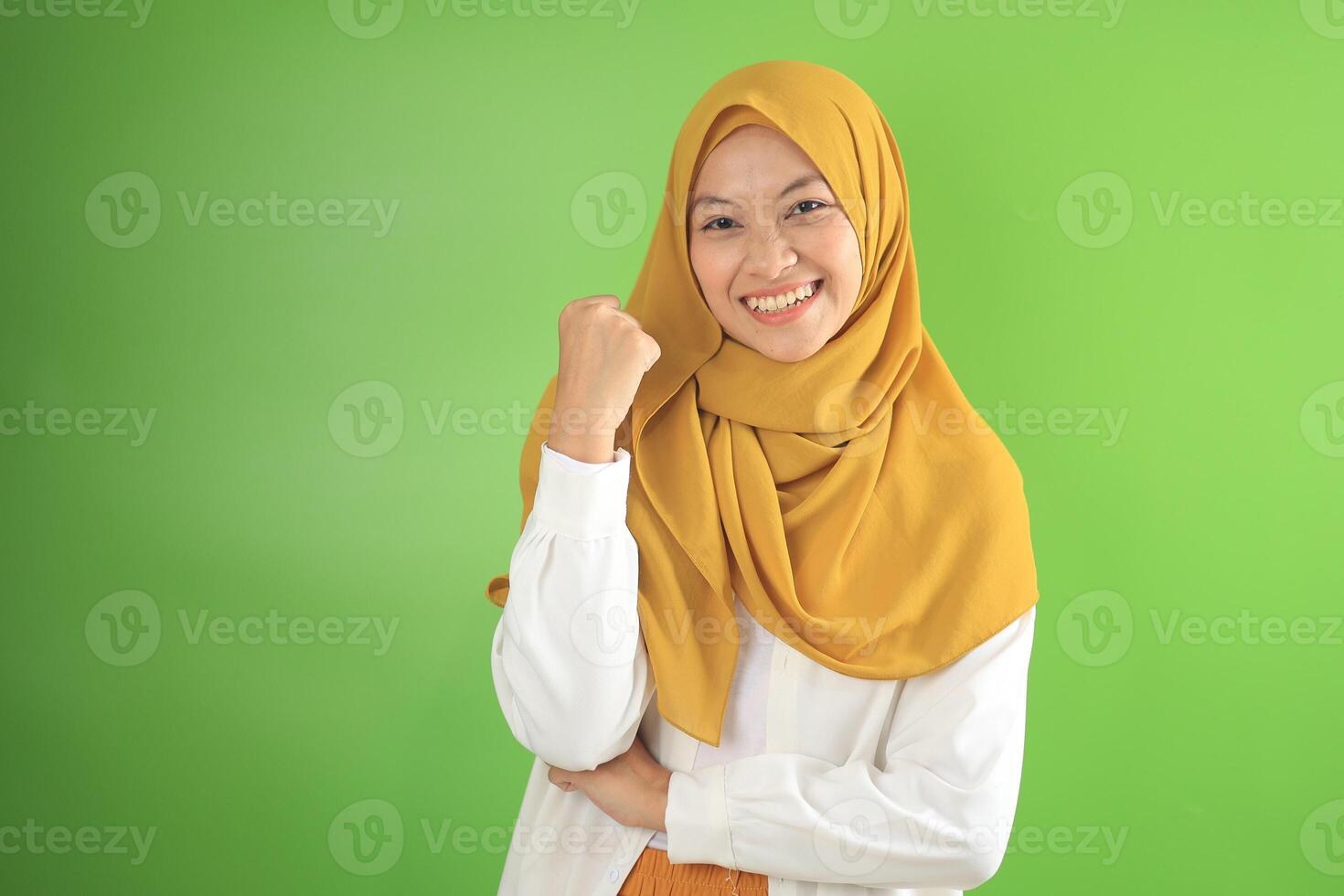 Young Asian Muslim Doing Winning Gesture Celebrating Fist Saying Yes photo