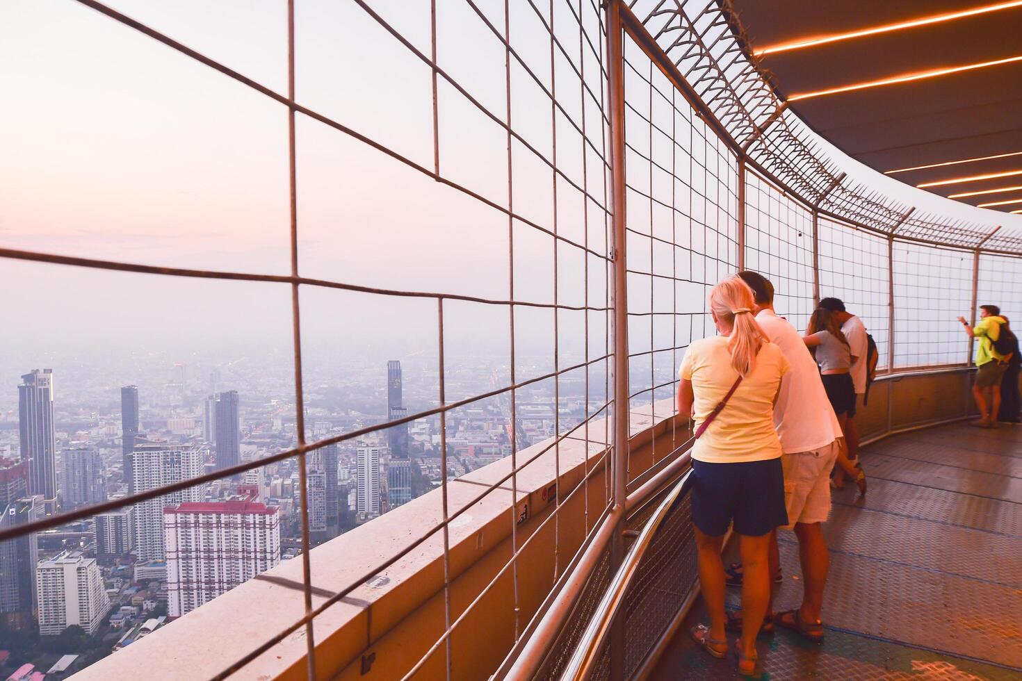 Bangkok ,Thailand - 25th march, 2024 - caucasian tourist family enjoy sunset over Bangkok city skyline from Baiyoke sky view revolving observation deck viewpoint in Thailands capital city photo