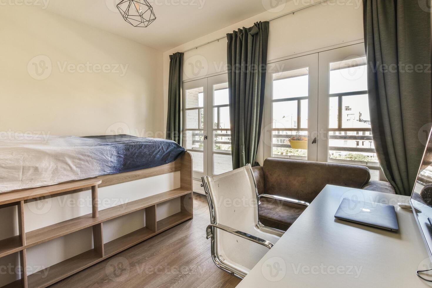 A bedroom with a bed, desk and window photo