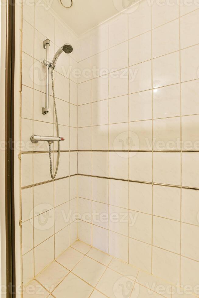 A shower with a shower head and a shower curtain photo