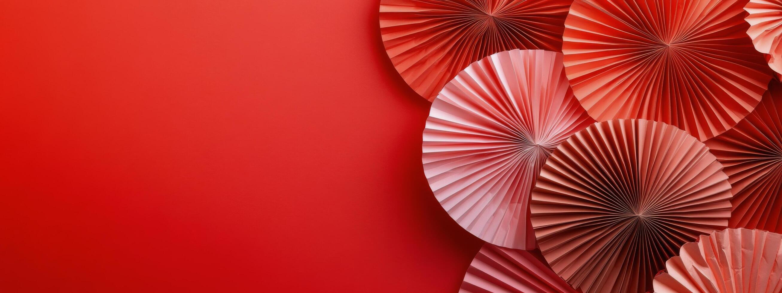 Colorful decorative paper fans arranged on a vibrant red background for a festive occasion photo