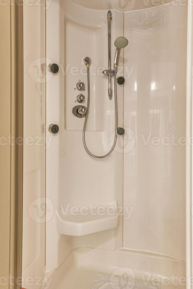A shower with a shower head and a shower seat photo
