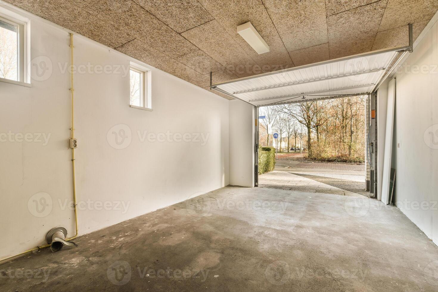 An empty garage with a door and a window photo