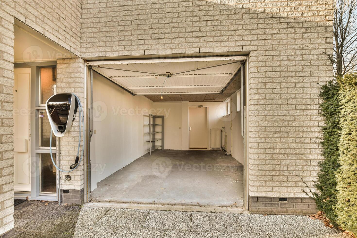A garage with a door open and a car in it photo