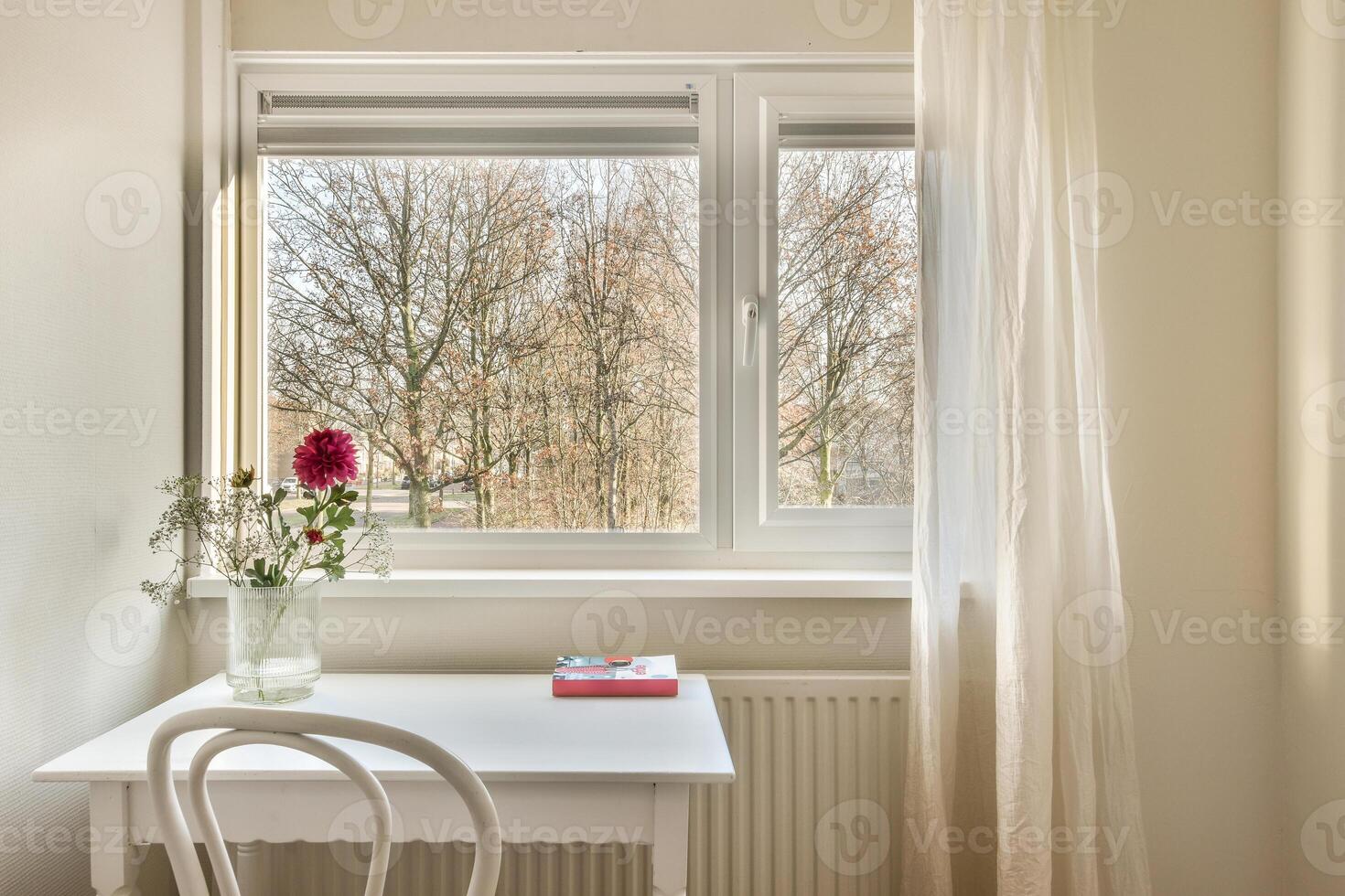 A white table with a vase of flowers sitting on it photo