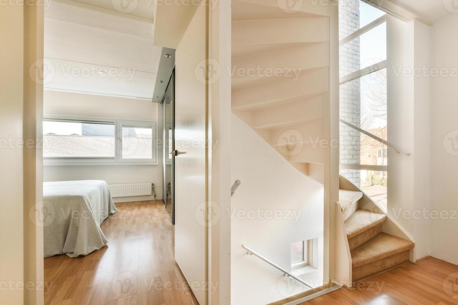 A bedroom with a bed and stairs leading to the next room photo