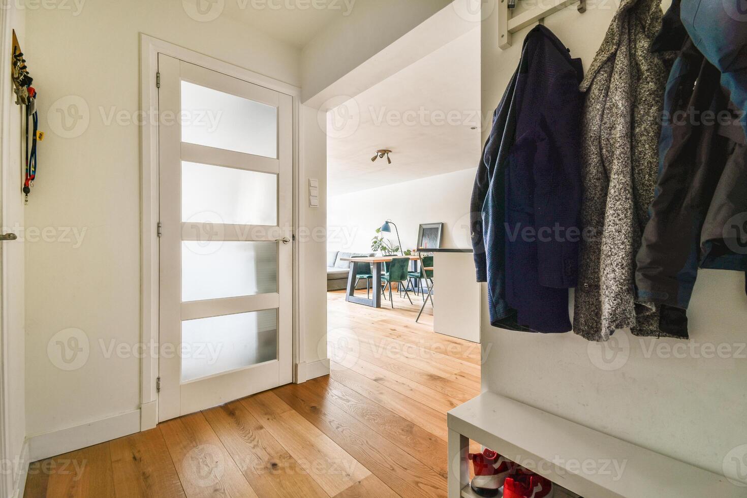 A hallway with a coat rack and a door photo