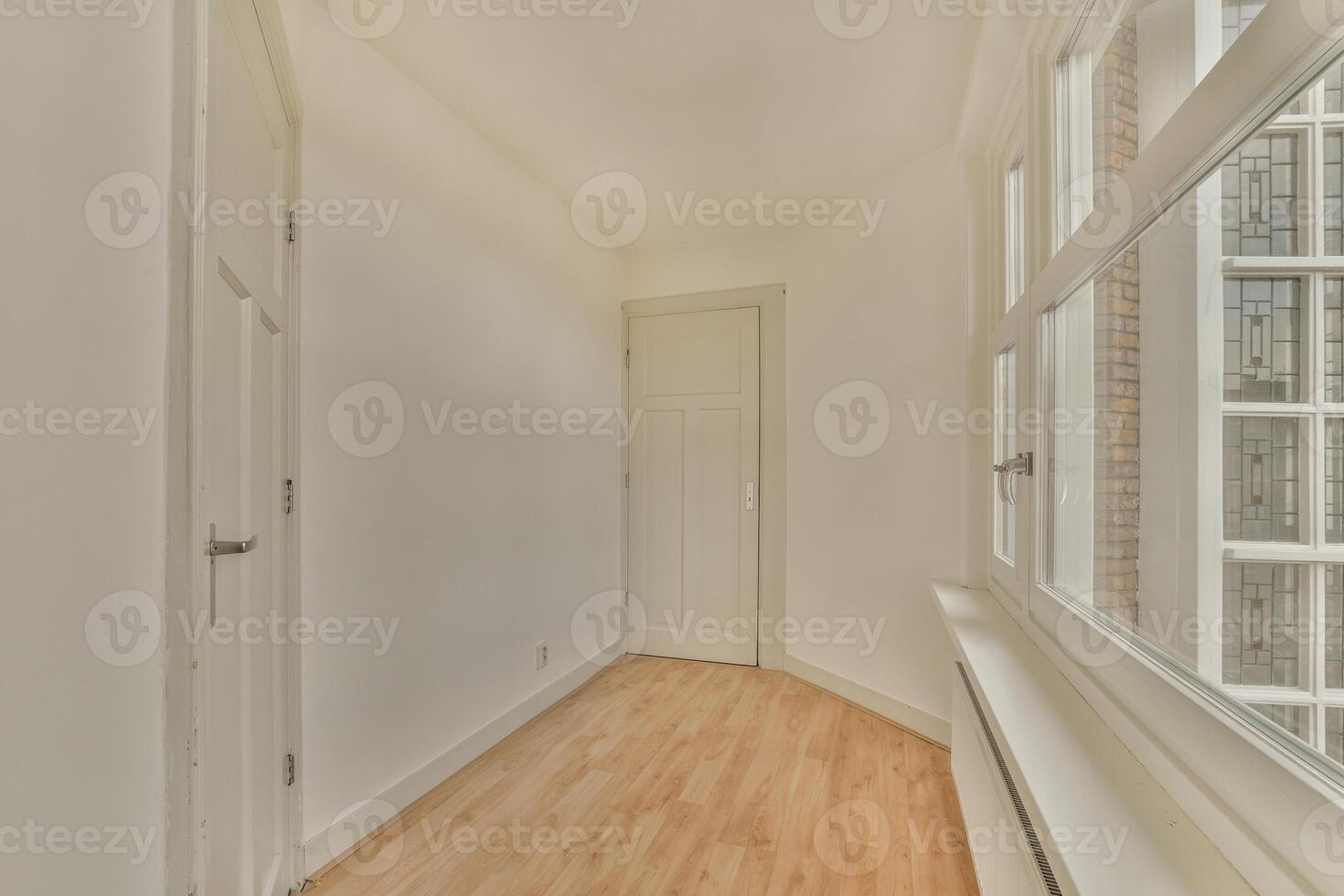 A hallway with a door and windows in it photo
