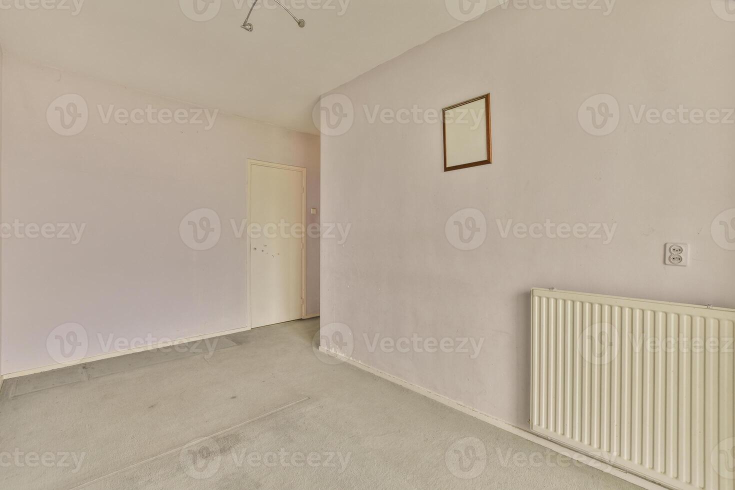 An empty room with a radiator and a picture on the wall photo