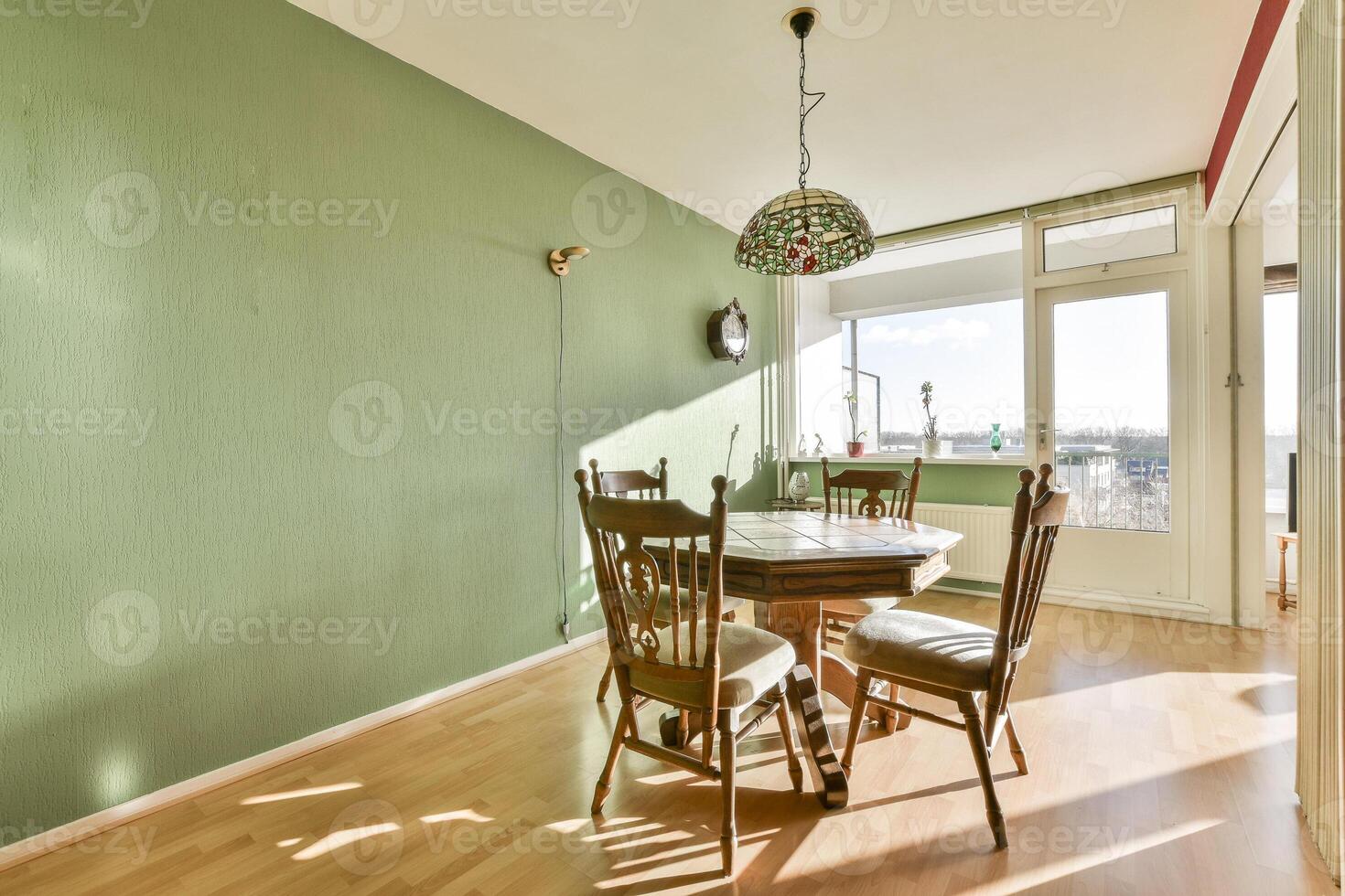 A dining room with a table and chairs in front of a window photo
