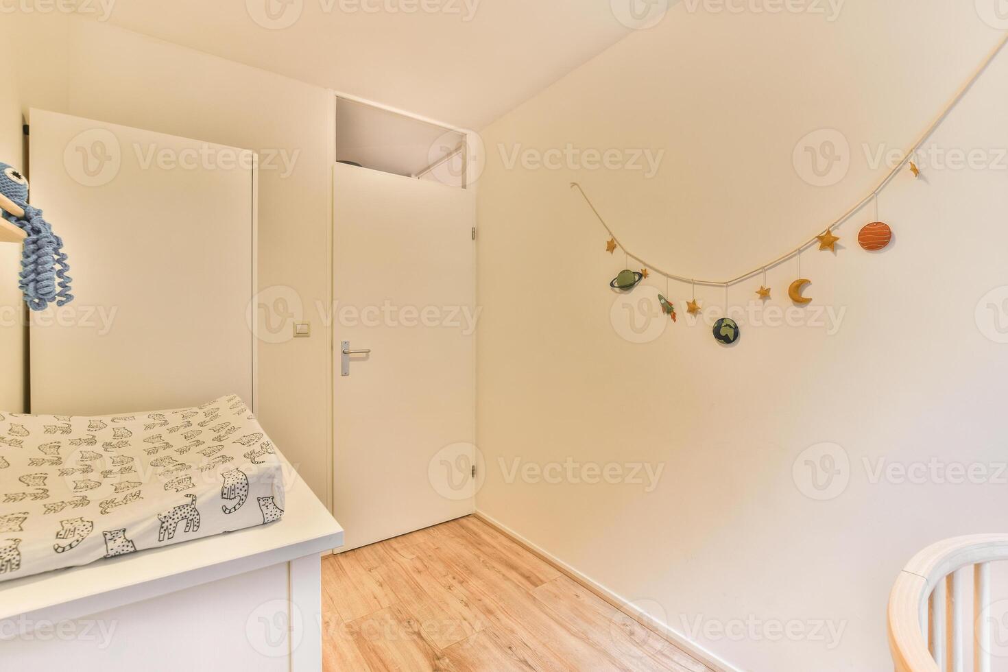 A small room with a crib, a changing table and a wall hanging photo