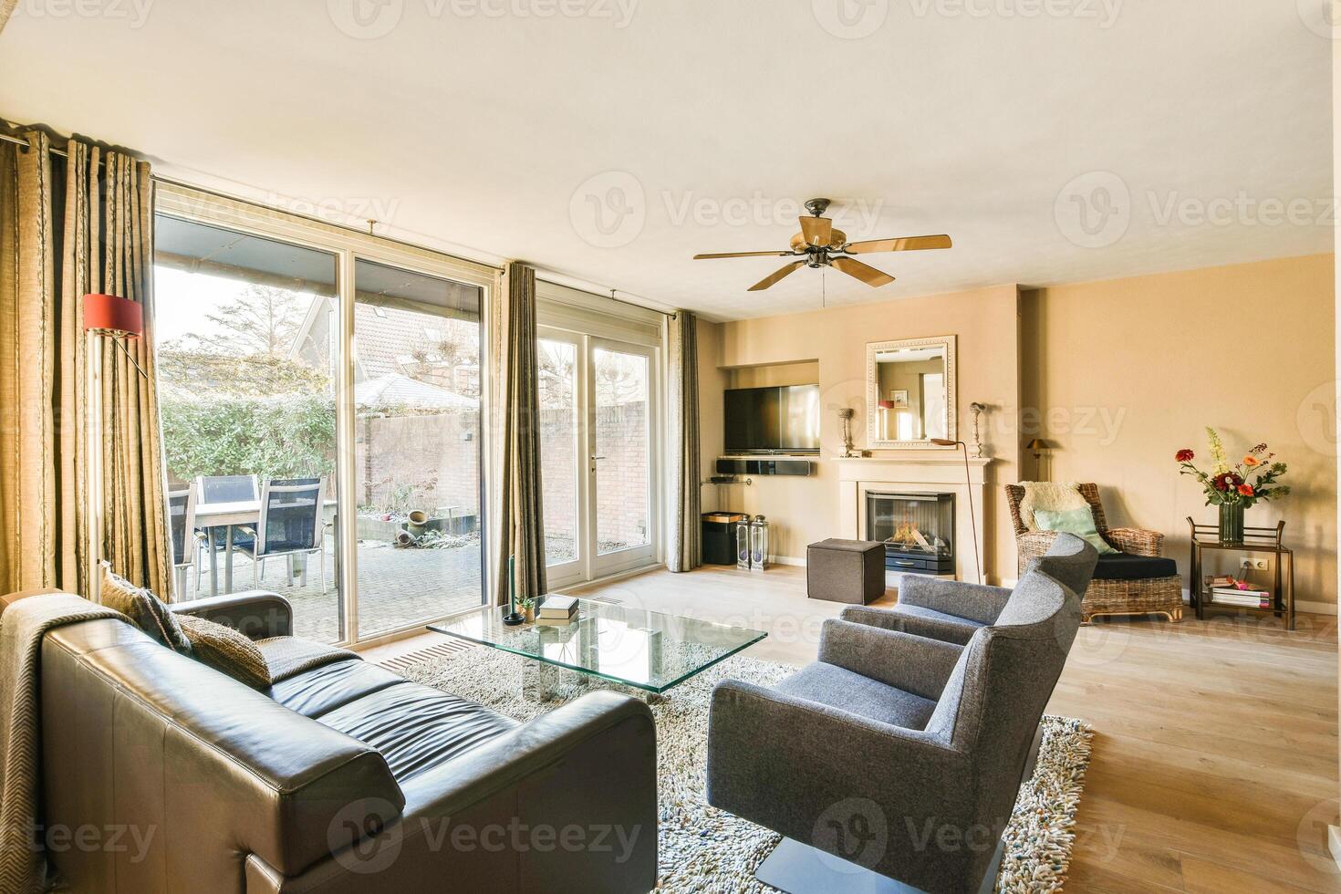 A living room with a couch, a television, a fireplace and a sliding glass door photo