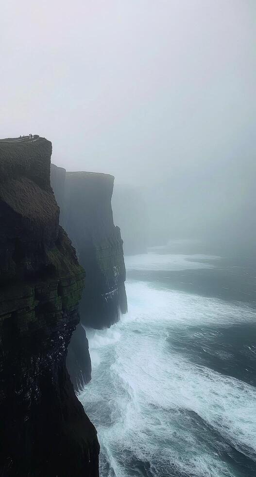 Misty cliffs at the edge of the atlantic ocean on a foggy day in ireland photo