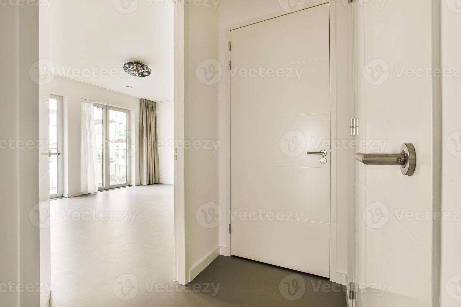 A white door is open in a room with a white floor photo