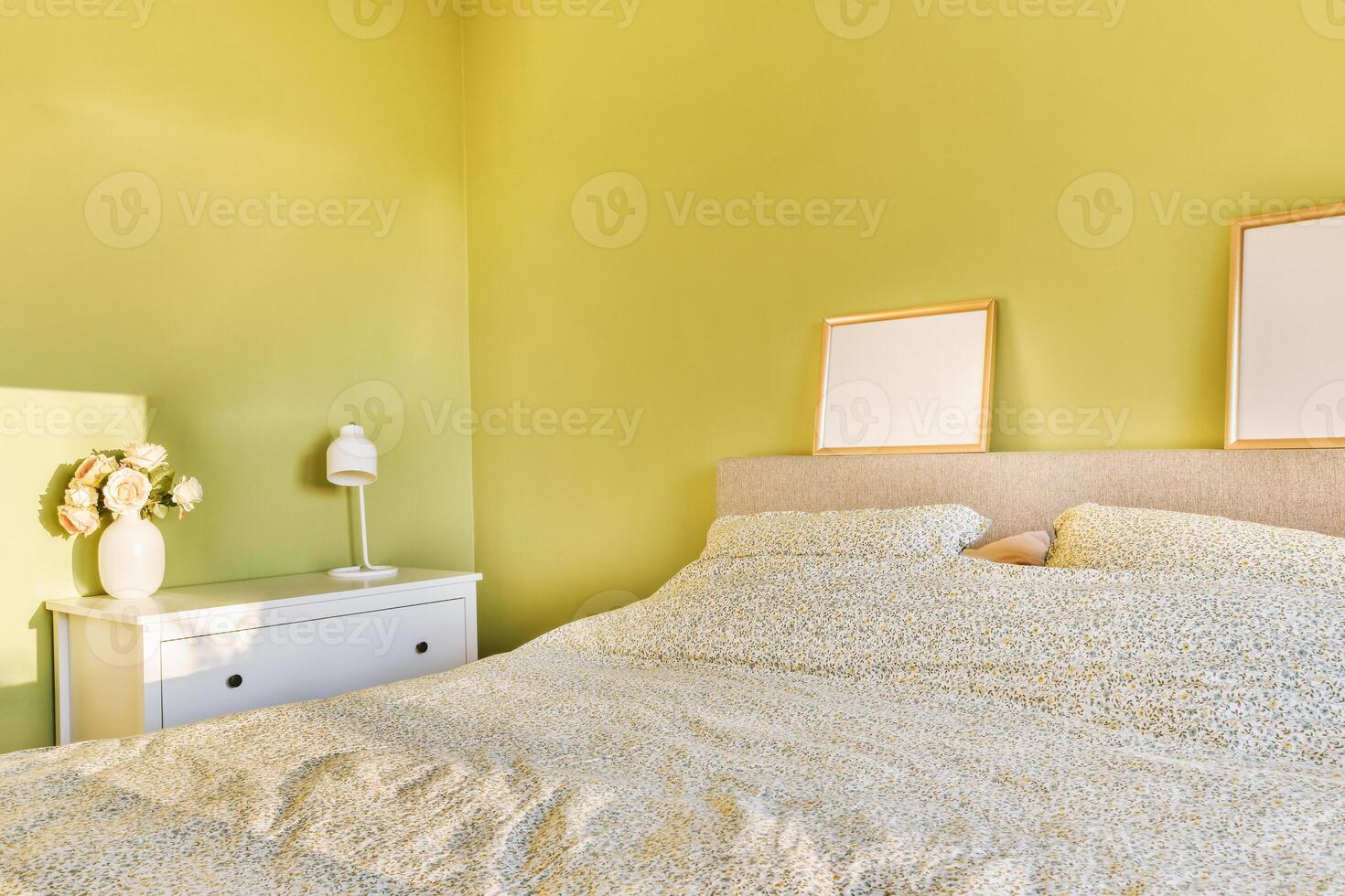 A bed with a white comforter and a white nightstand photo