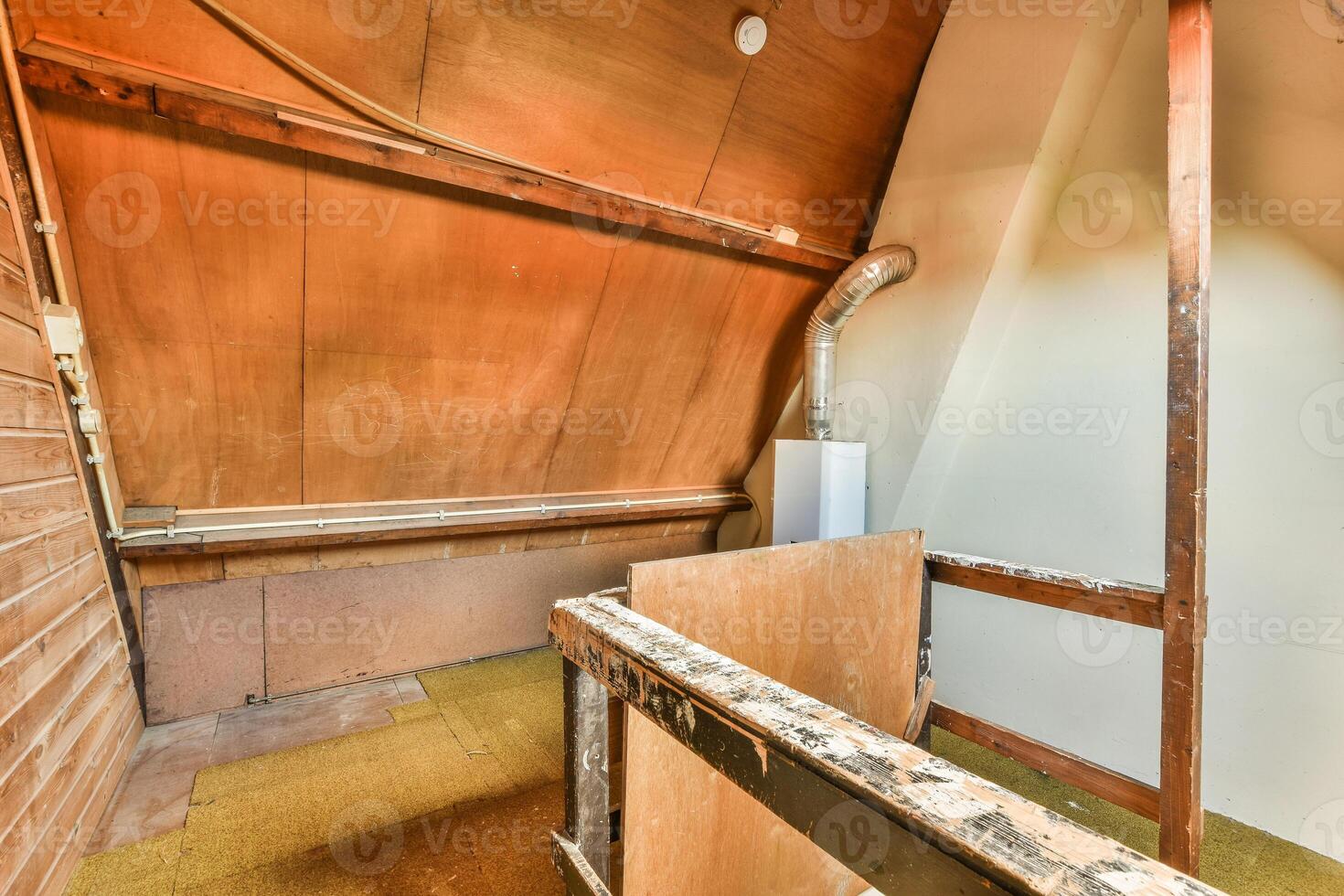 An attic with a ladder and a wooden floor photo