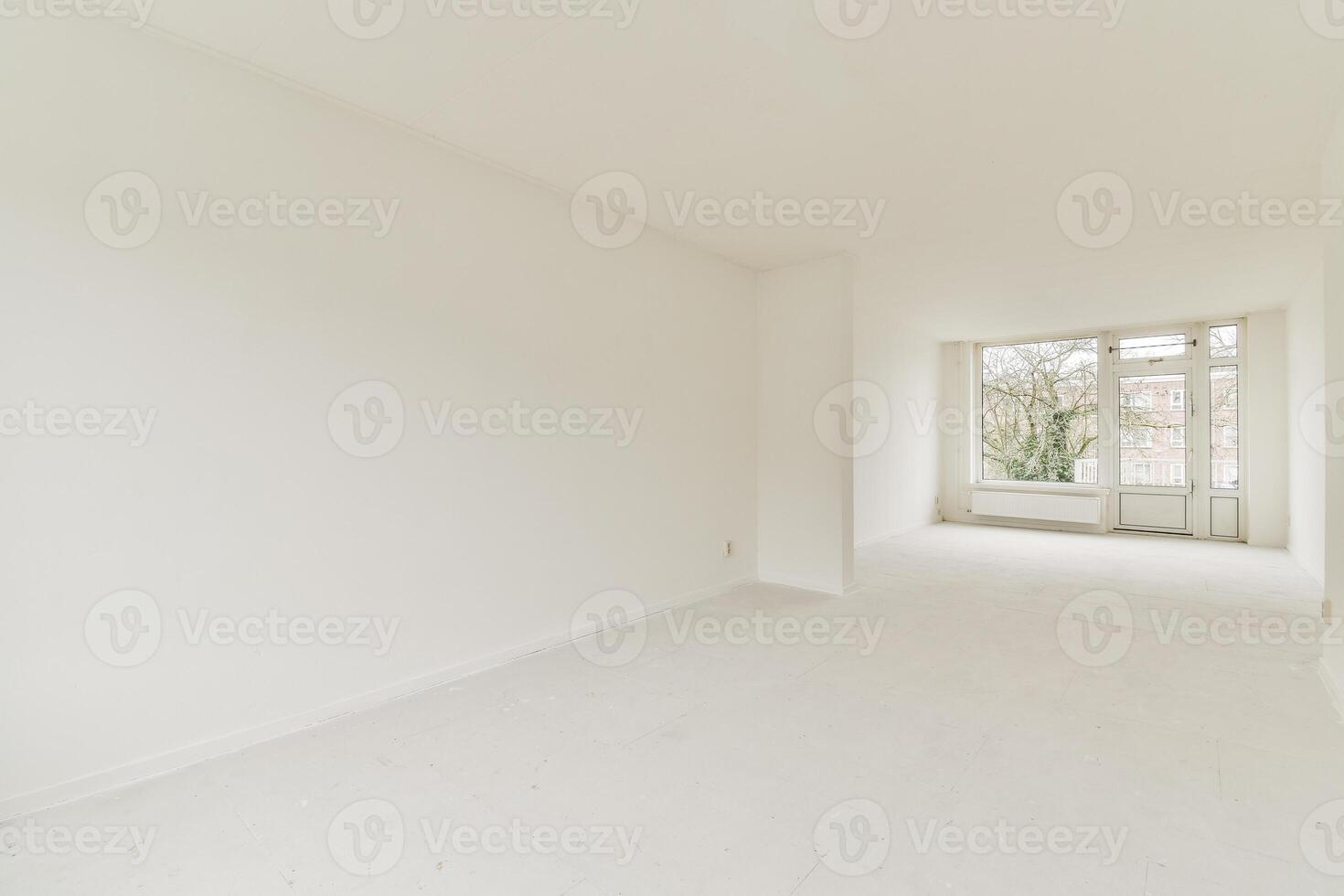 An empty room with white walls and a large window photo