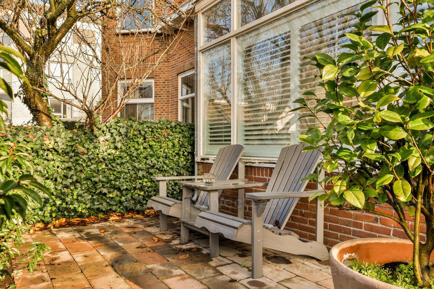 A brick patio with a bench and a tree photo