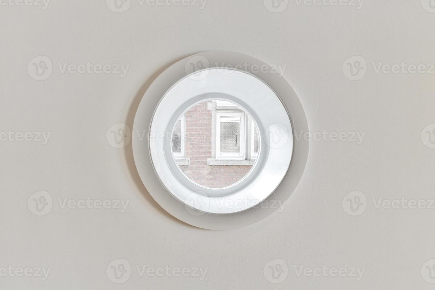 A circular mirror is mounted on the wall photo