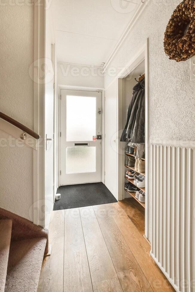 A hallway with a door and a coat rack photo