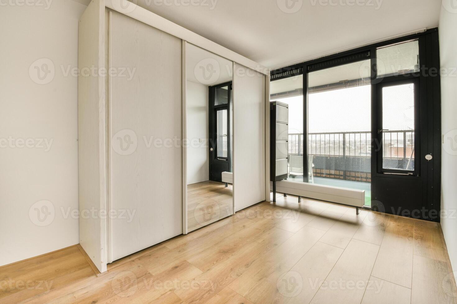 A room with a sliding door and wooden floors photo