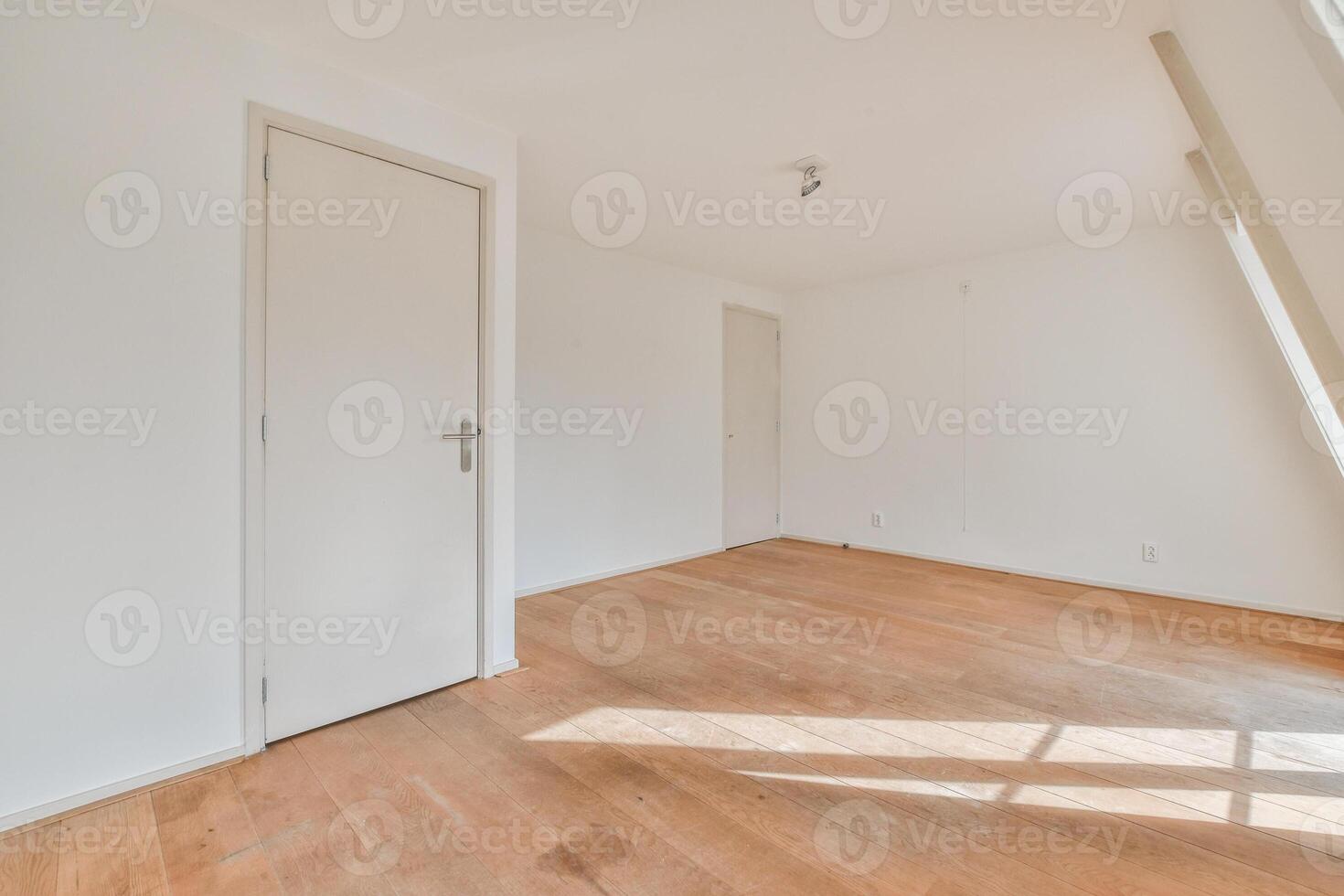 An empty room with wooden floors and white walls photo