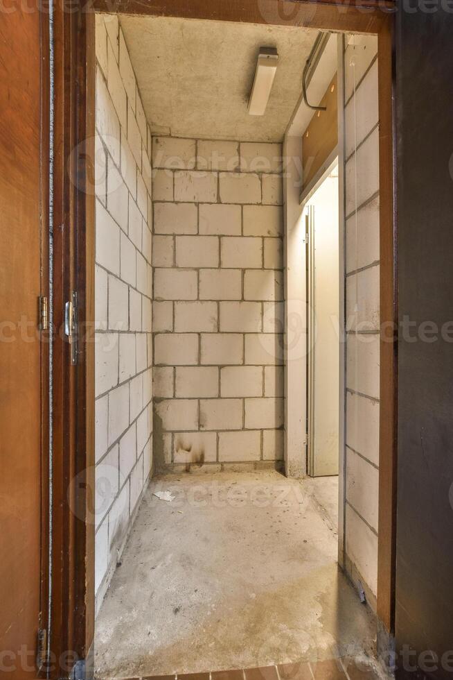 An empty room with a brick wall and a door photo