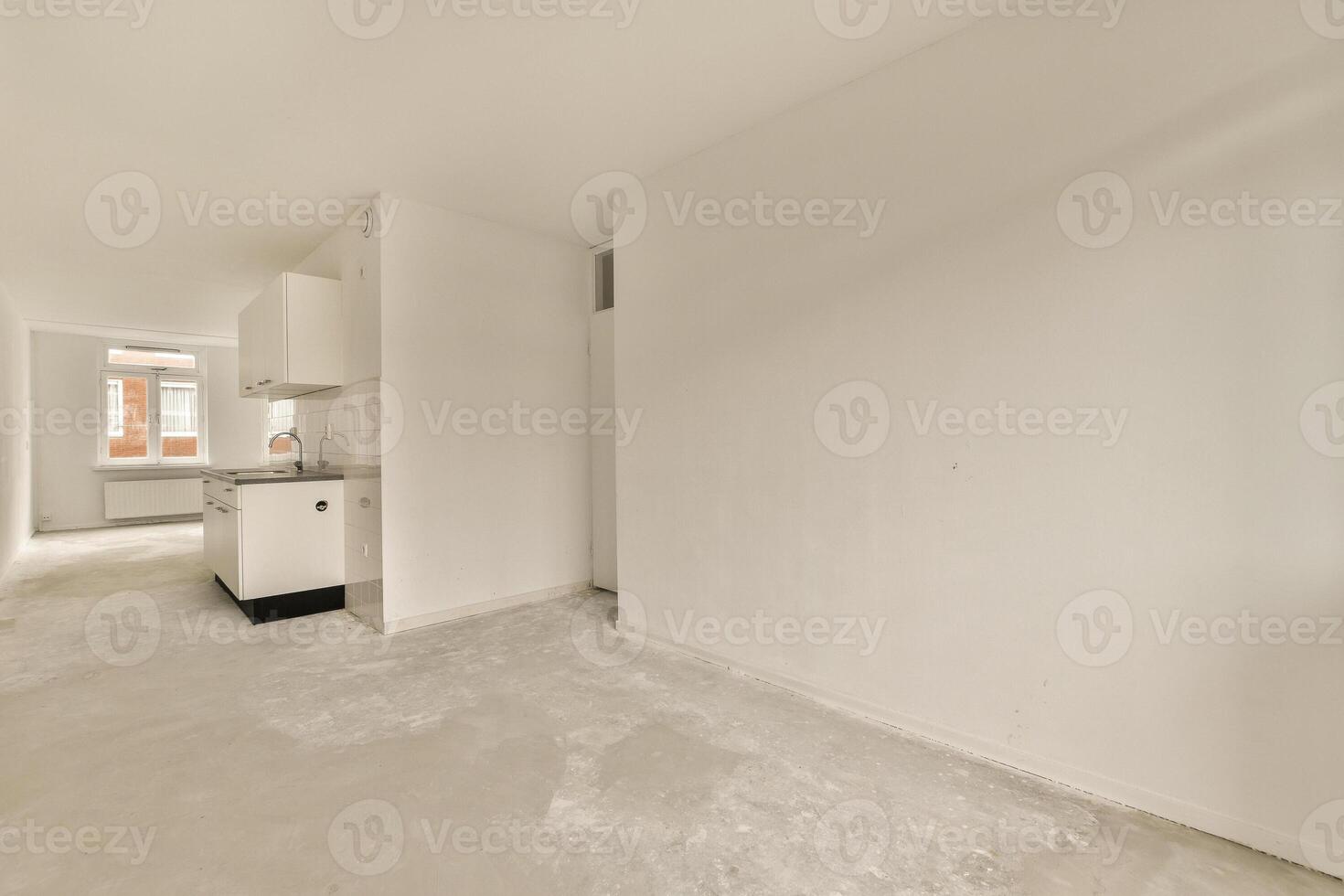An empty room with white walls and a sink photo