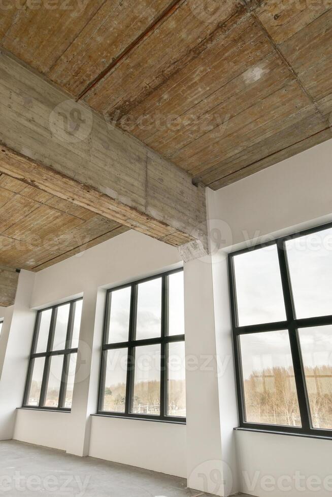 Empty room with large windows and wooden ceiling photo
