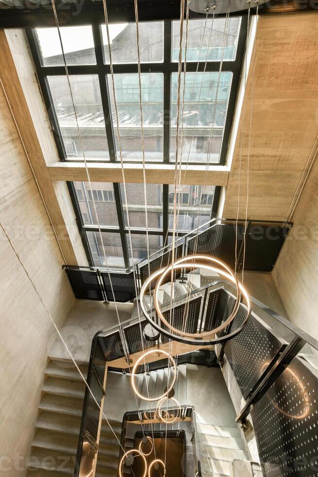 A staircase with a circular light fixture hanging from the ceiling photo