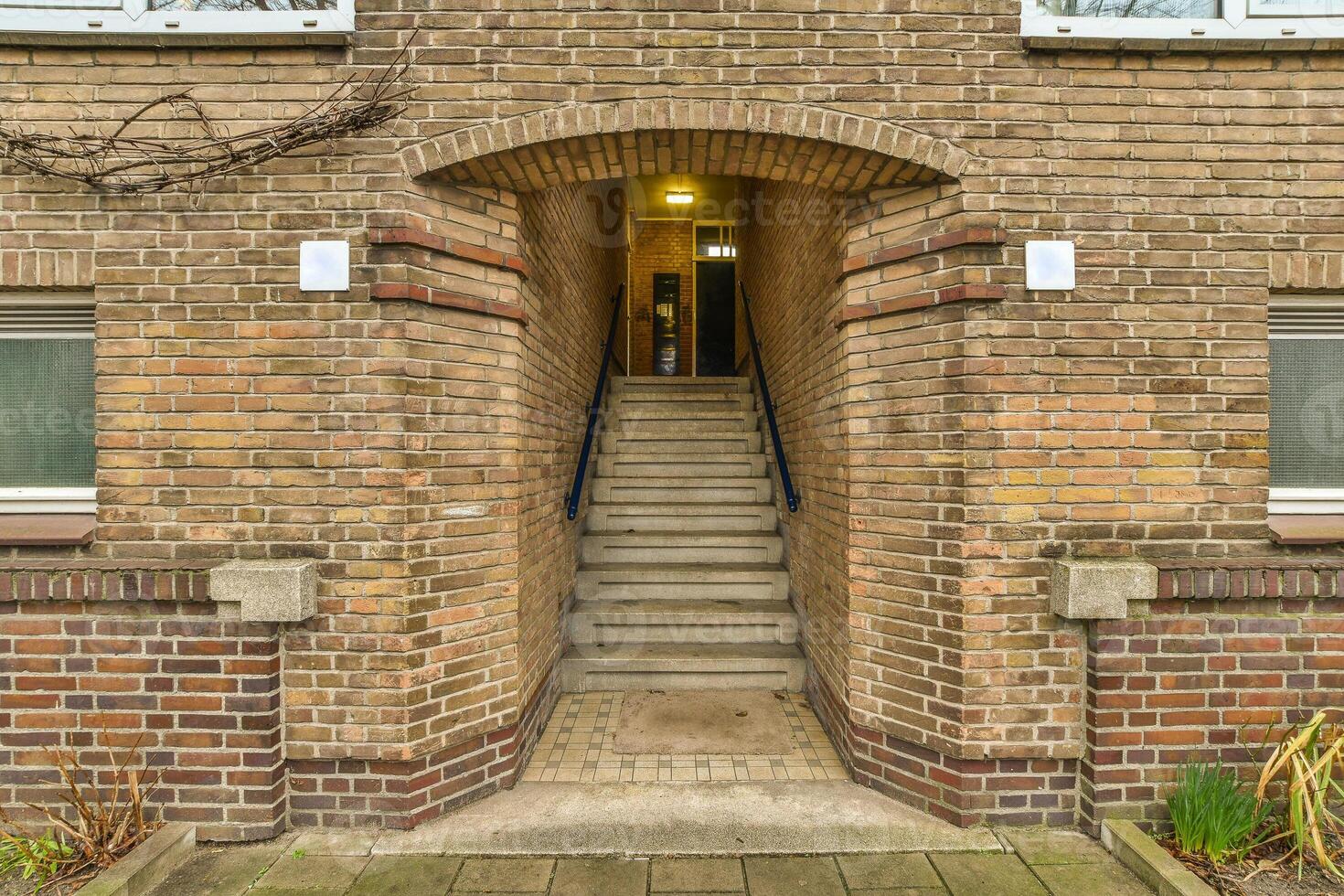 A brick building with a stairway leading up to it photo