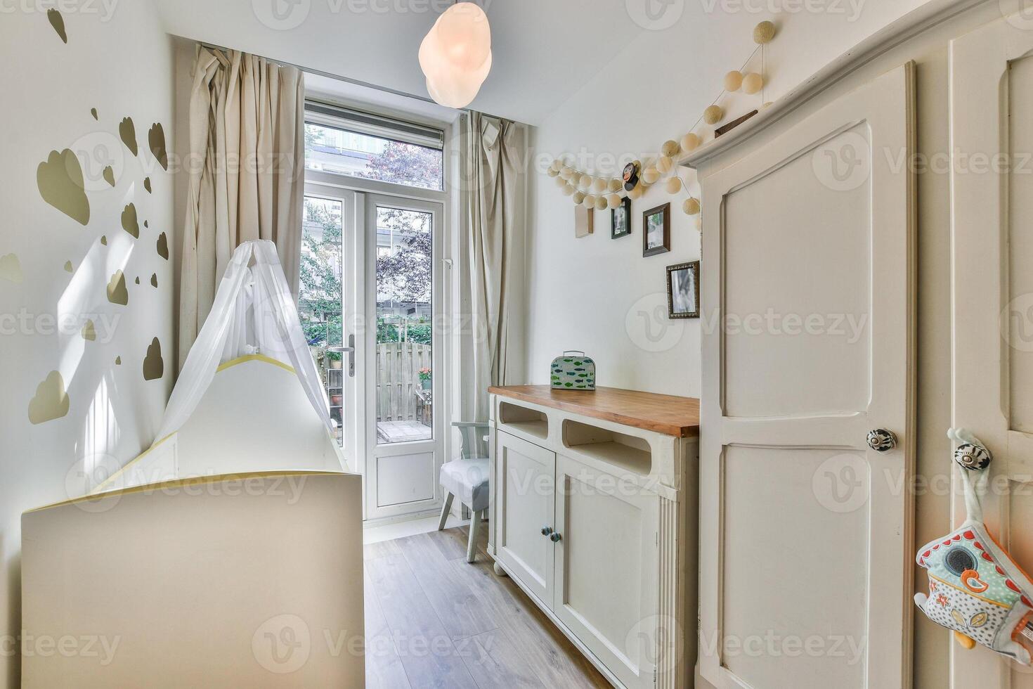A small room with a crib, a dresser and a window photo