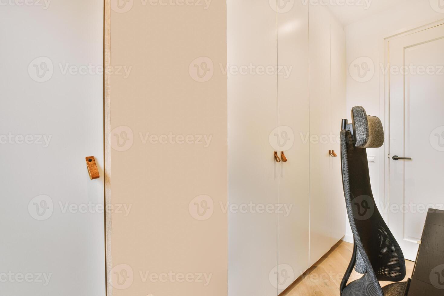 A chair in a room with a desk and a door photo