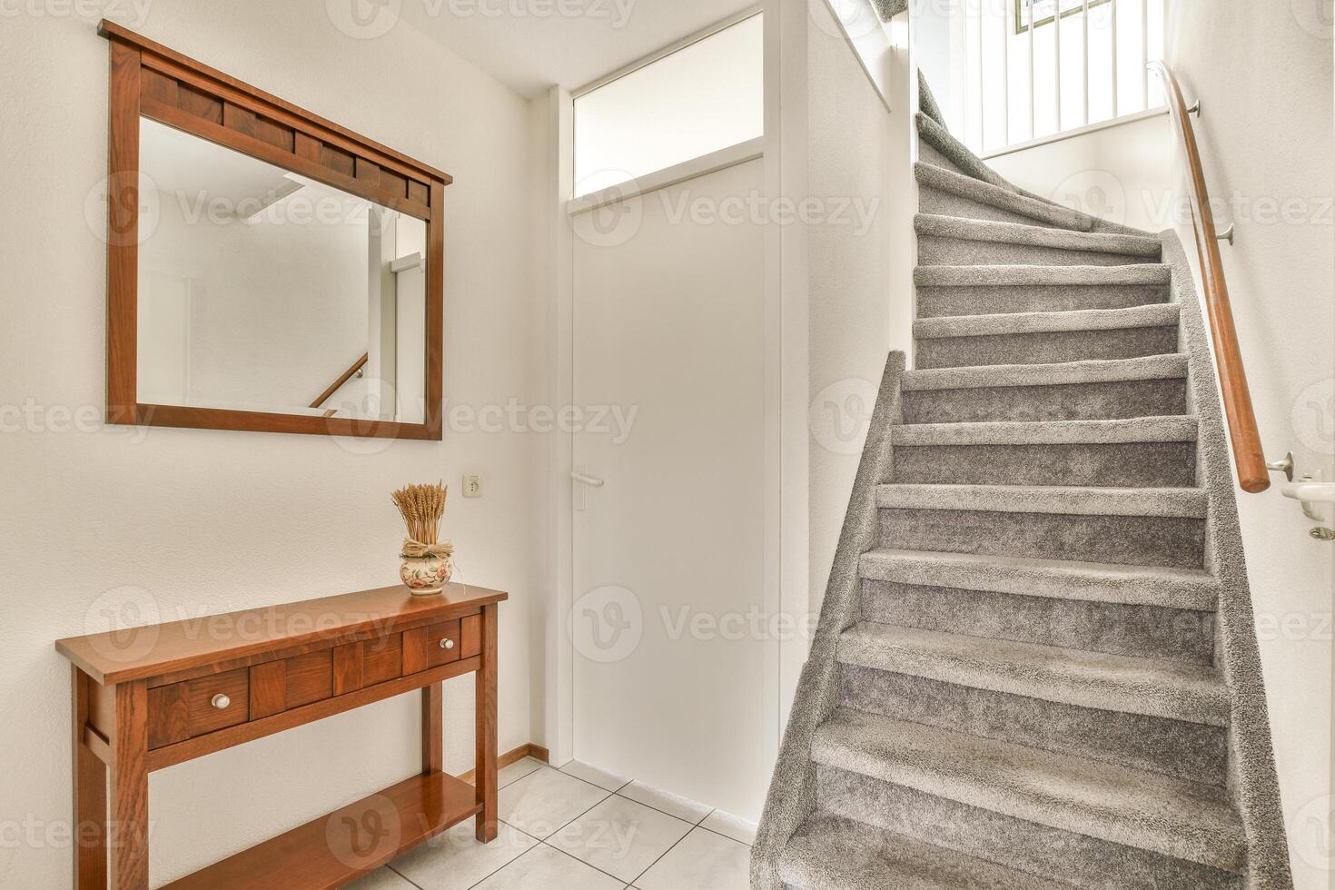 A hallway with a wooden table and stairs photo