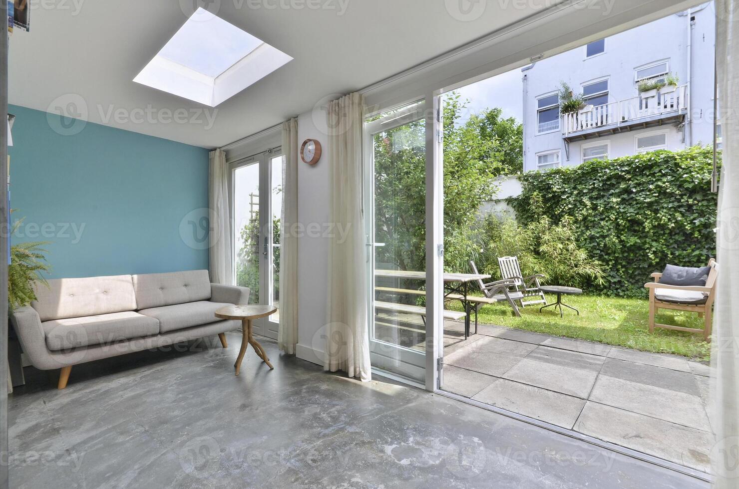 A living room with a patio and a skylight photo