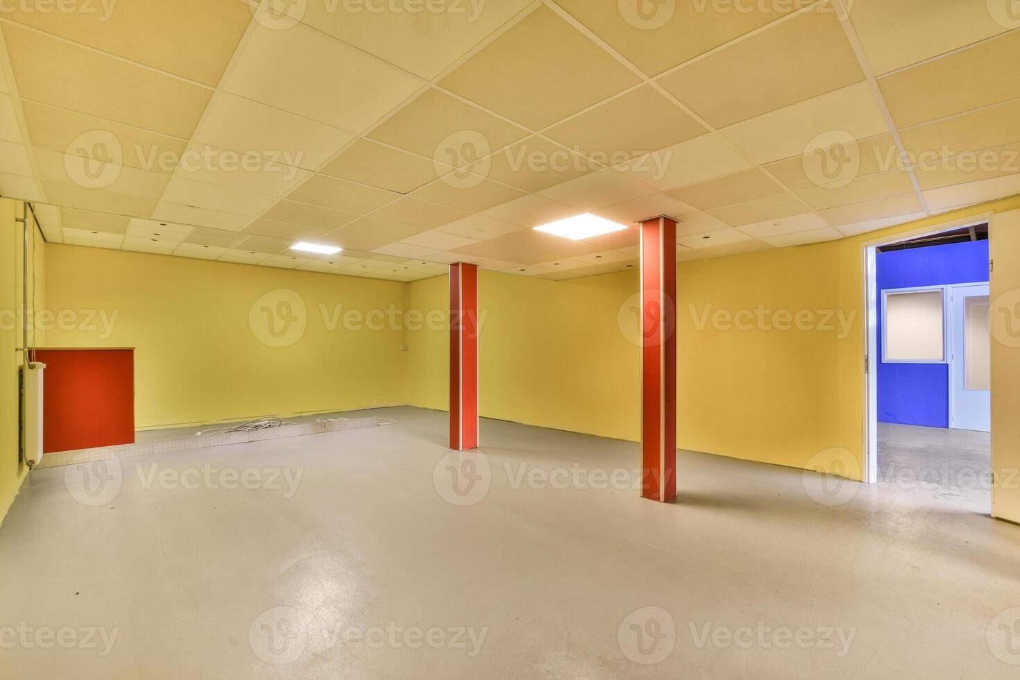 An empty room with yellow walls and red pillars photo