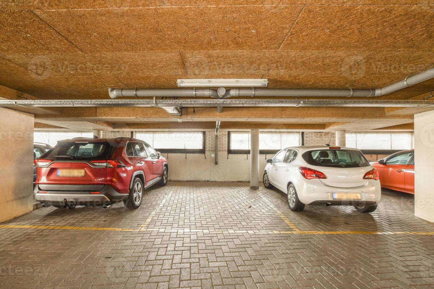 Three cars parked in a parking garage photo