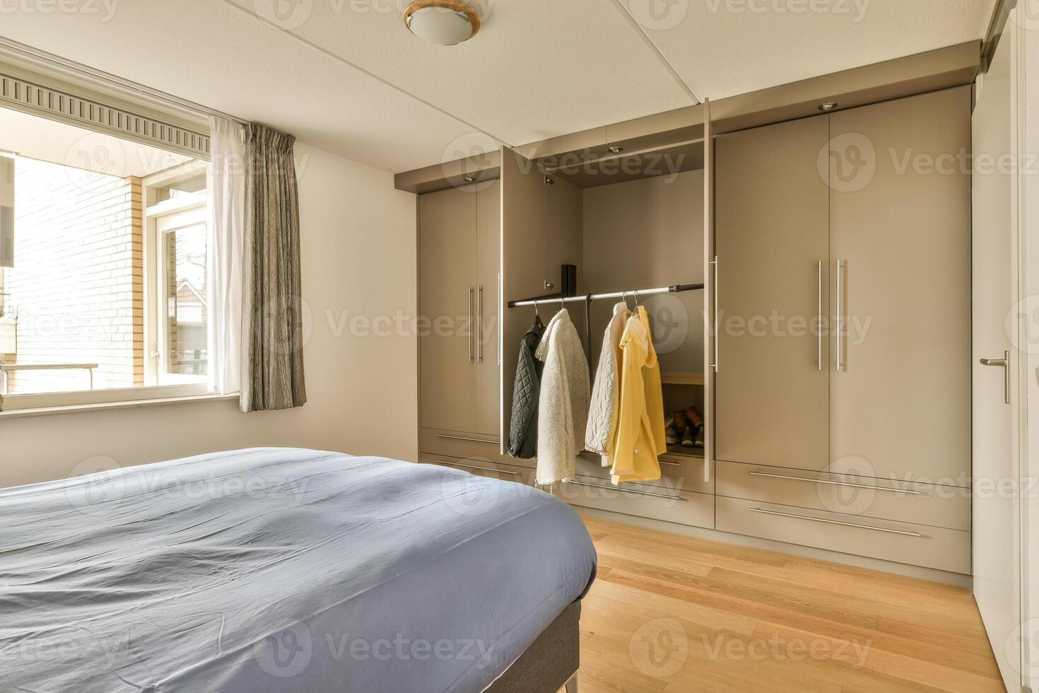 A bedroom with a bed, closet and a window photo