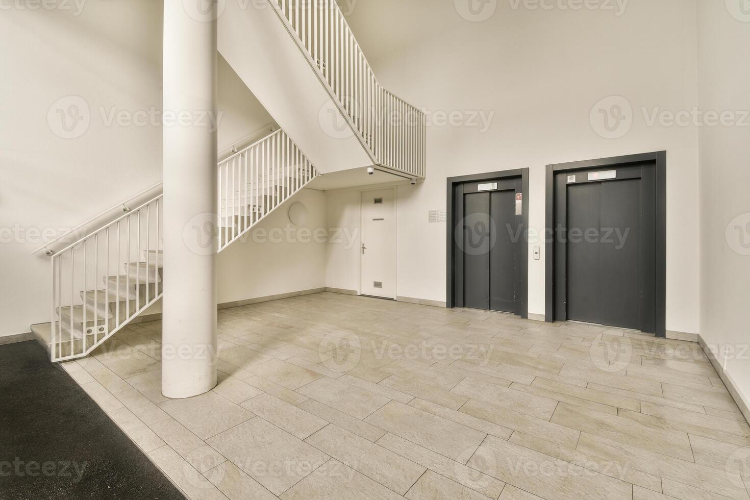An empty hallway with two elevators and stairs photo