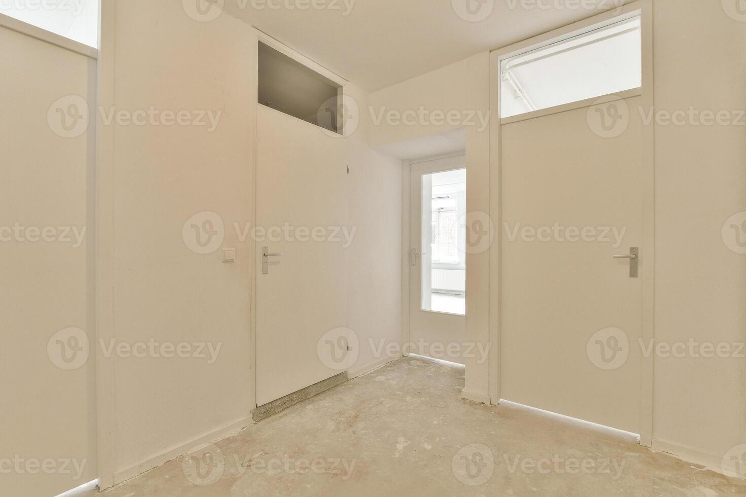 A white hallway with two doors and a window photo
