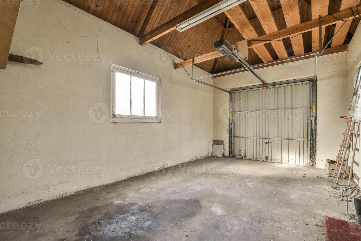 An empty garage with a ceiling fan and a window photo
