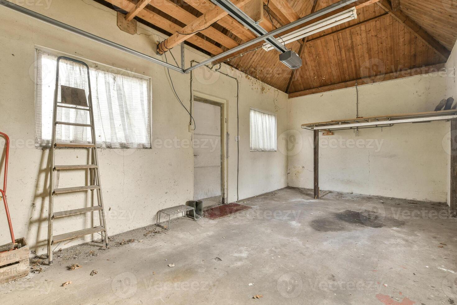 An empty garage with a ladder and ladder photo