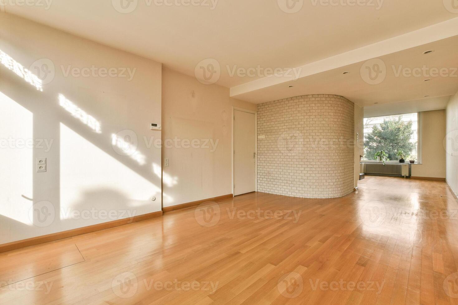 An empty room with hardwood floors and a wall photo
